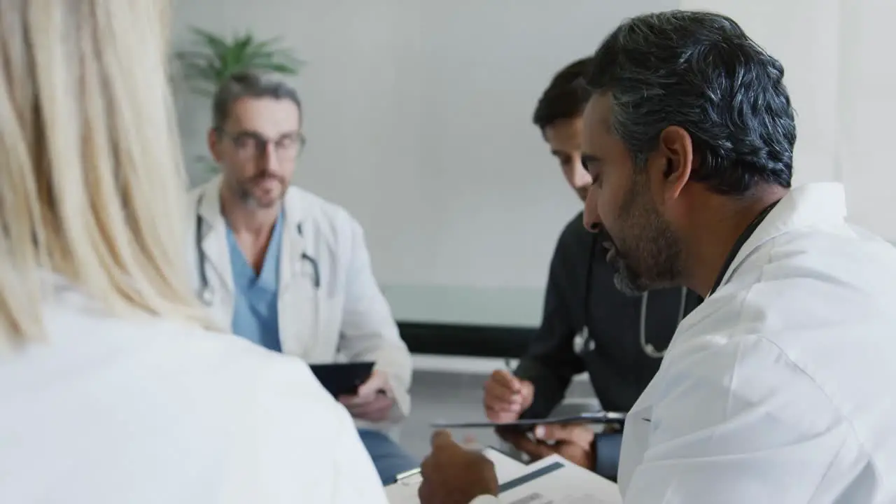 Doctors sit talking in a meeting 4k