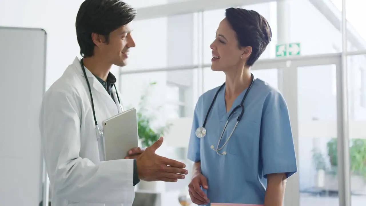 Male and female doctor shaking hands in hospital 4k