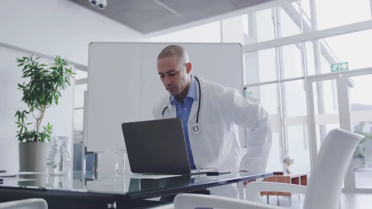 Male doctor sitting at a desk in office 4k