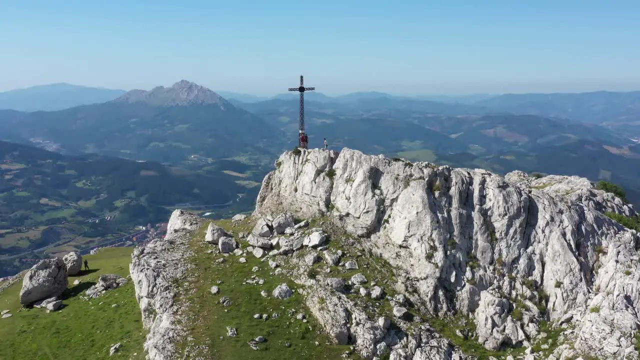 Aerial drone view of a large iron cross on top of a mountain in the Basque Country