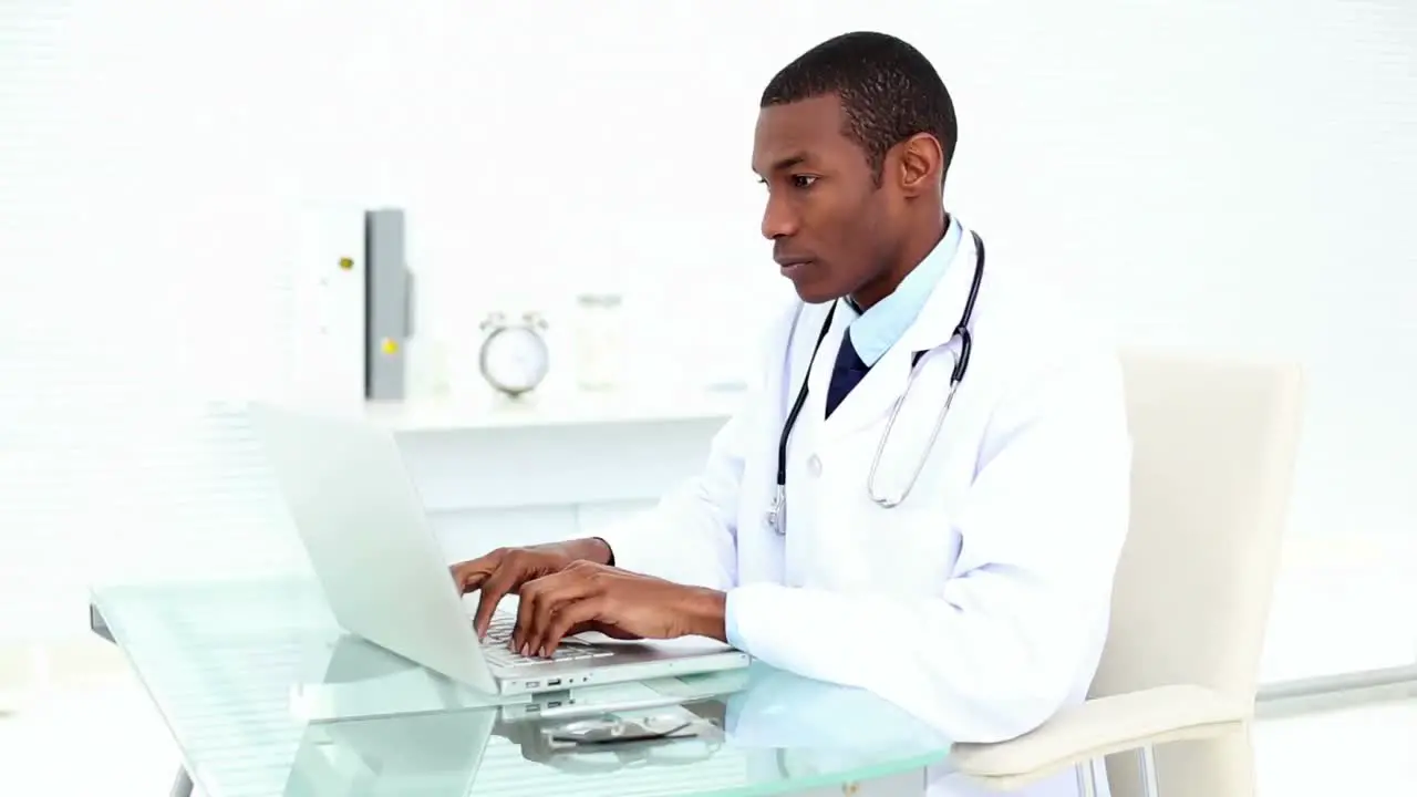 Serious doctor working on his laptop