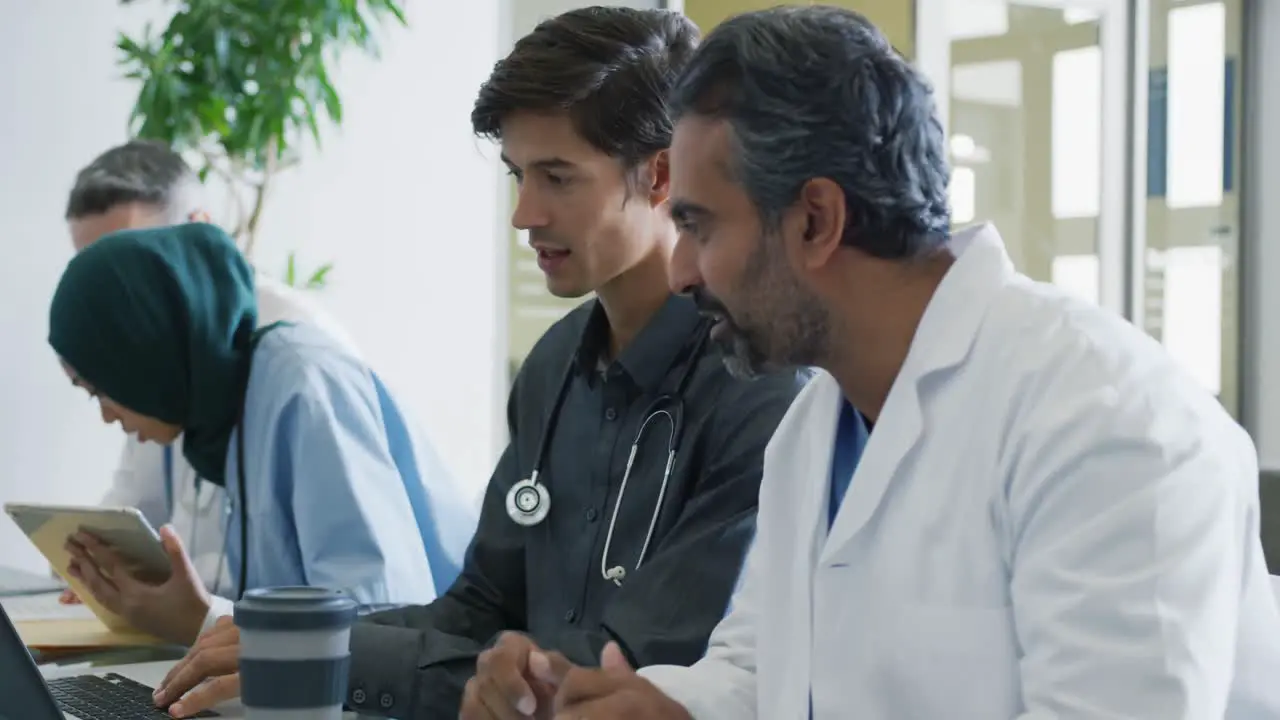 Doctors sit working together at a table 4k