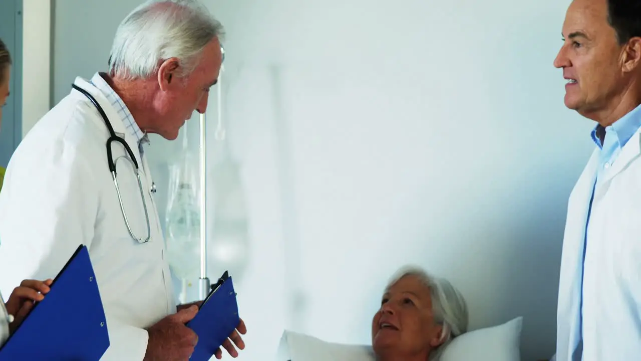 Group of doctors discussing report with old woman