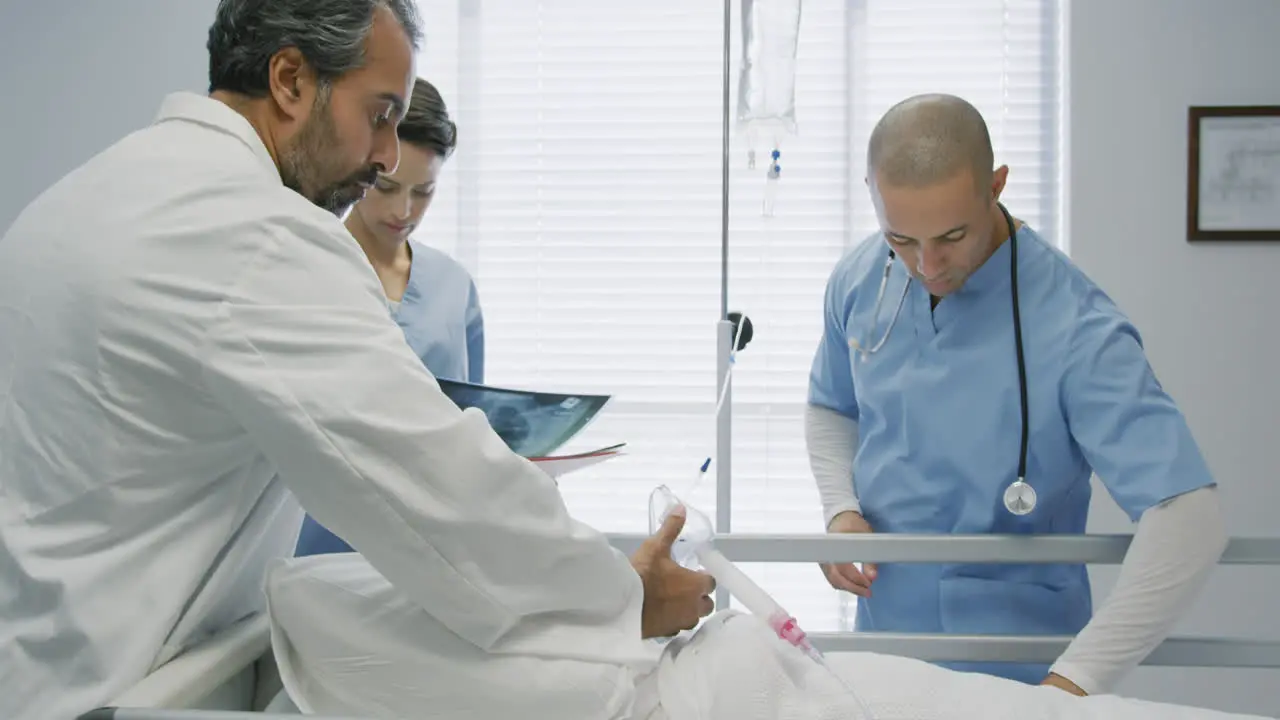 Doctors putting mask on patient in hospital bed 4k