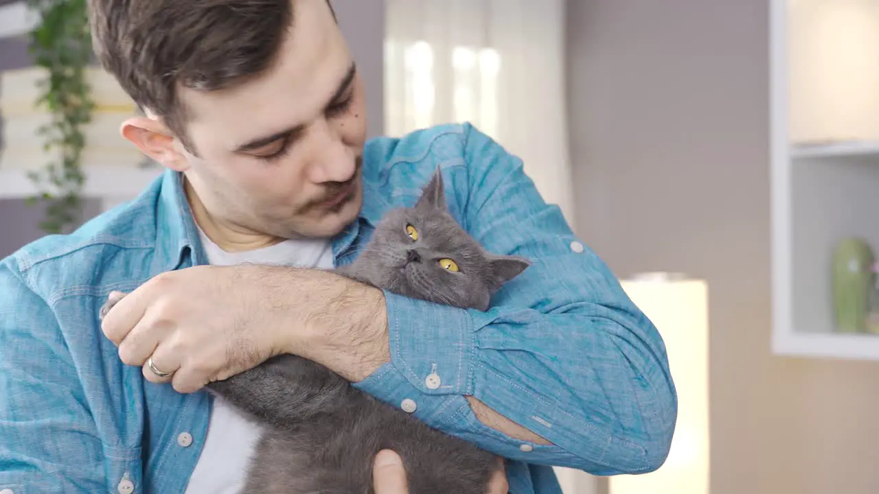 Young man kissing and hugging his cat