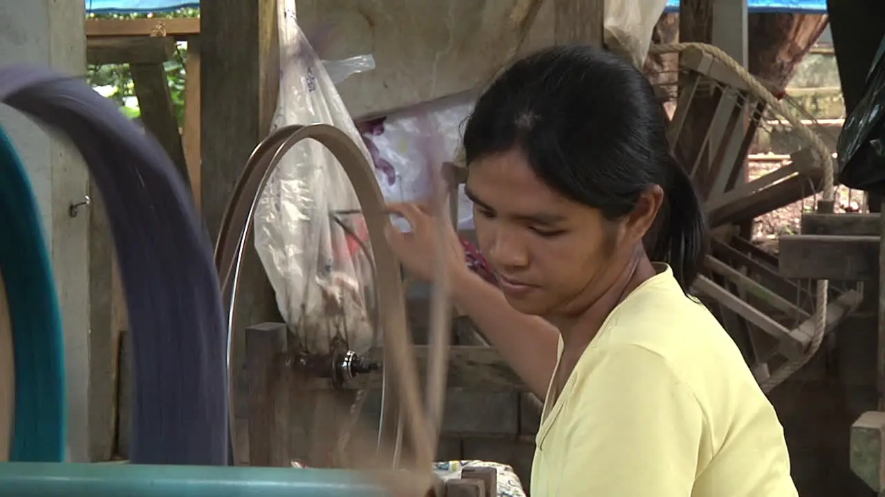 Medium Shot Of Femaile Traditionally Spinning Thread in Thailand