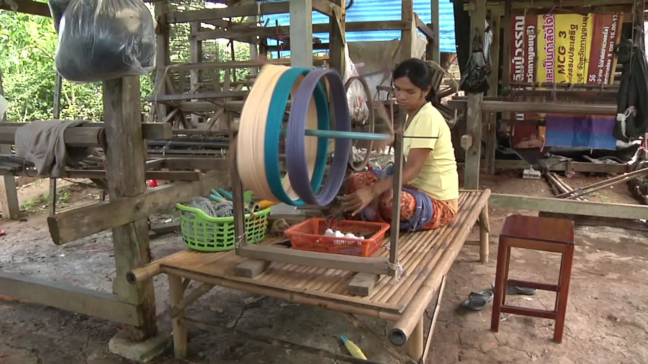 Wide Shot Of Femaile Traditionally Spinning Thread in Thailand Kanchanaburi