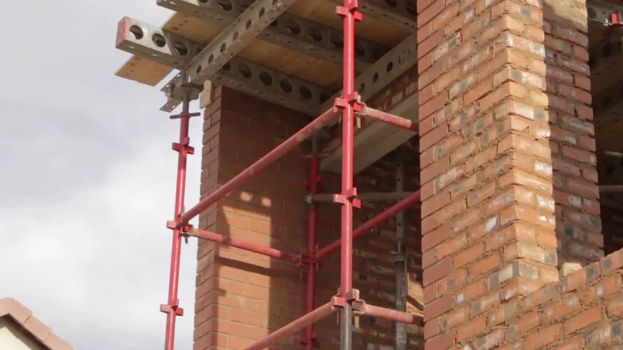 Tilt shot of new house construction site showing scaffolding on second floor