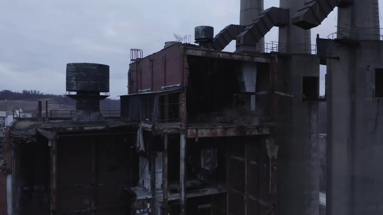 Drone reveal shot of an abandoned factory in a industrial zone next to a river