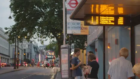 Passengers Waiting At Bust Stop On Busy Road In London England UK