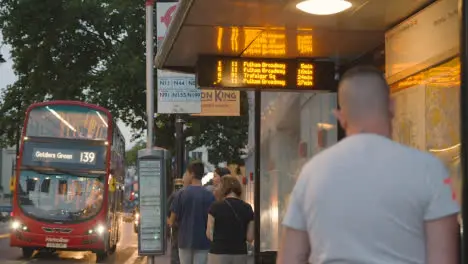 Passengers Waiting At Bust Stop On Busy Road In London England UK 1