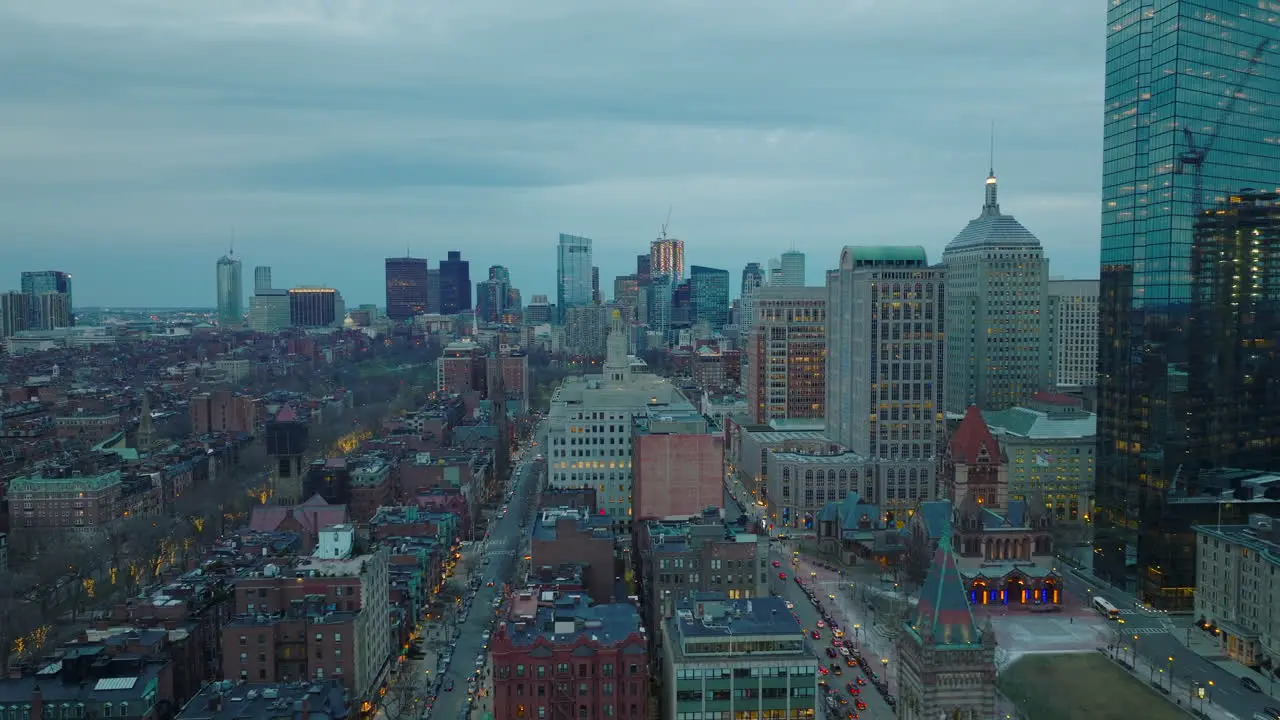 Fly above residential buildings in Back Bay Borough Cityscape with modern high rise buildings in distance Twilight in large city Boston USA