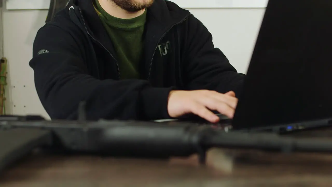 Man behind a counter in an arms store 2