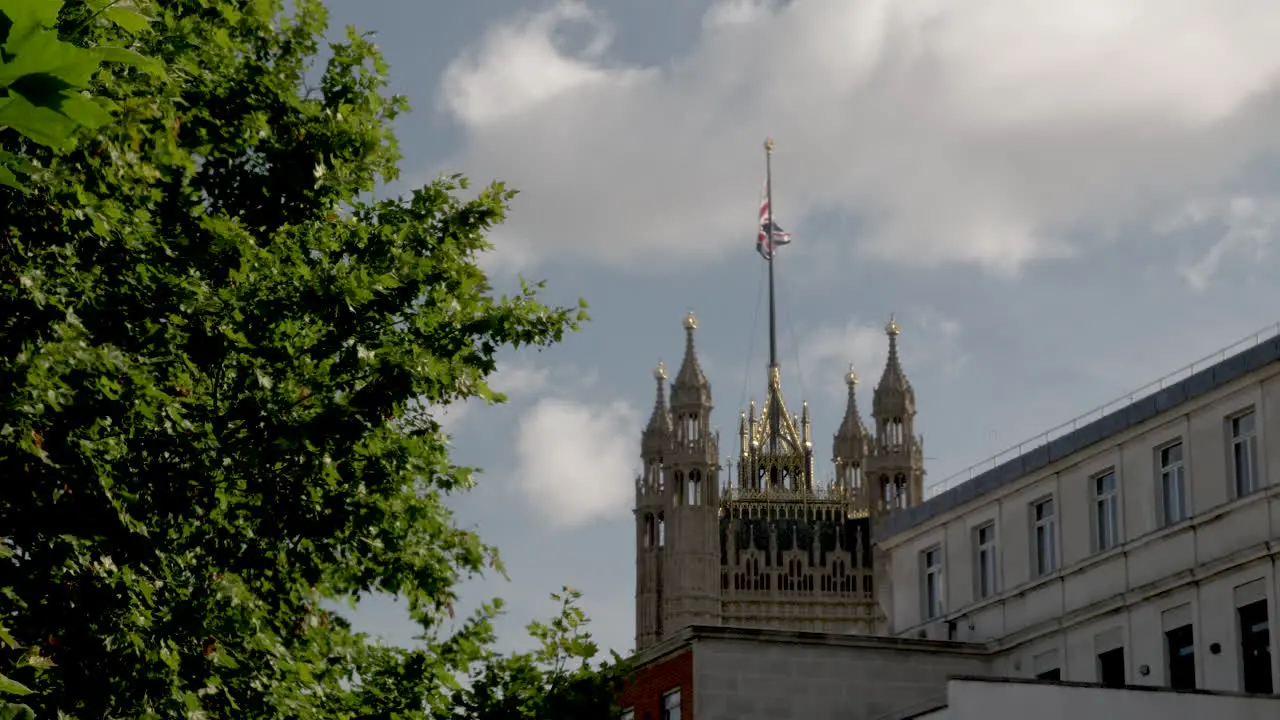 A distant shot of the Victoria Tower with a Union Jack flag fluttering in the wind at Westminster Palace London England