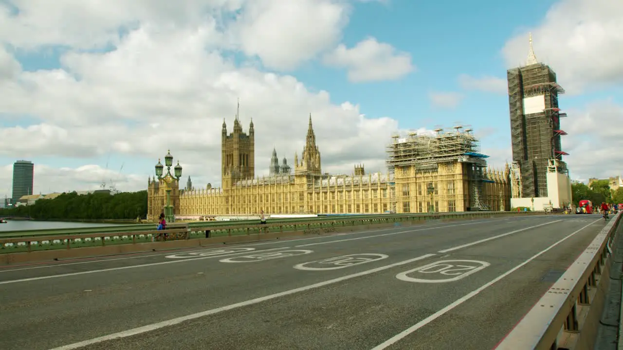 Lockdown in London runners and cyclists cross empty Westminster Bridge streets with Big Ben under scaffolding during the Coronavirus pandemic 2020