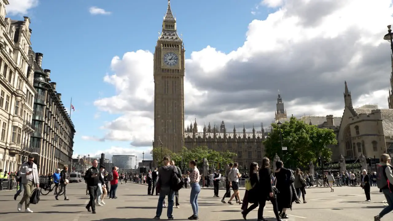 Low angle shot of tourists and locals walking along Parliament Square London UK at daytime