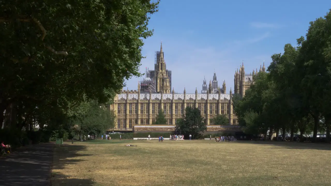 Victoria Tower Gardens park by the Houses of Parliament in Westminster London with tourists and locals in the background