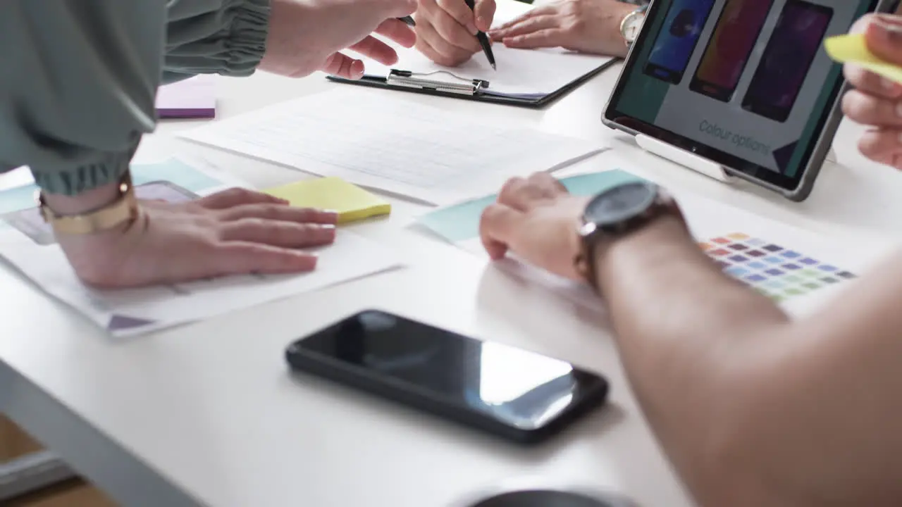 Group of people discussing over color options and design layouts on a business table