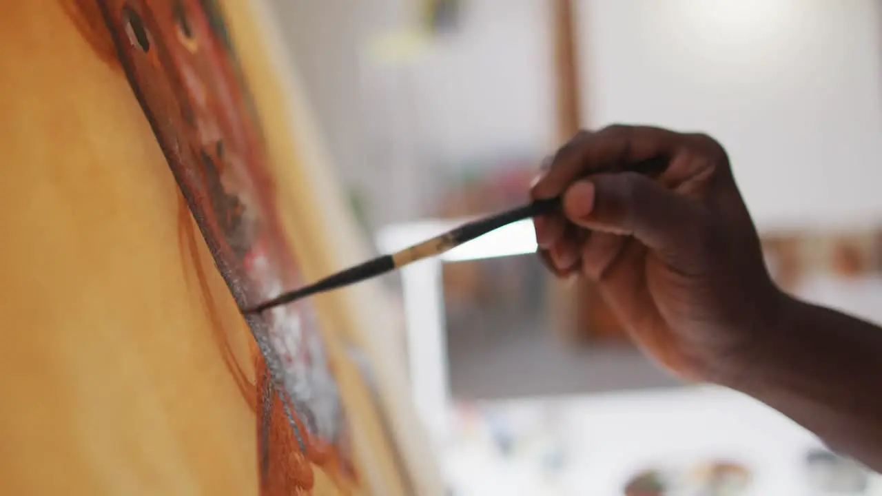 Close up of male artist painting on canvas at art studio