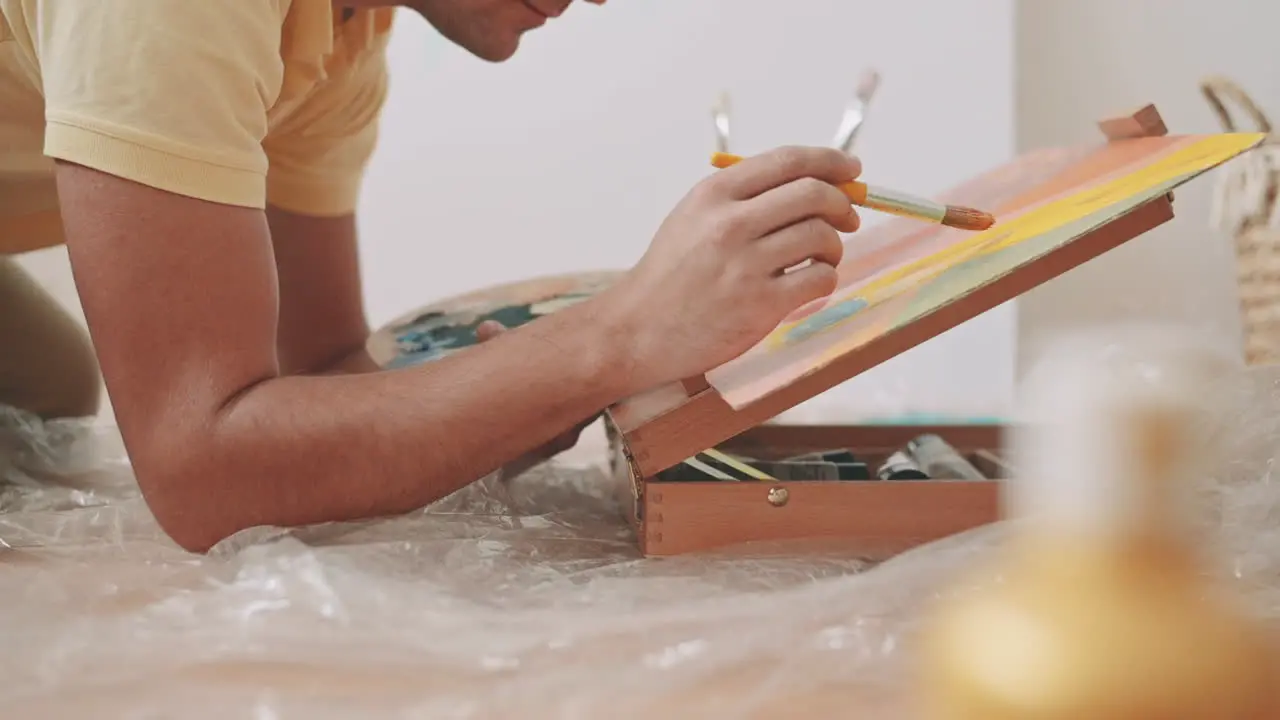 The Hands Of An Unrecognizable Man Painting A Canvas