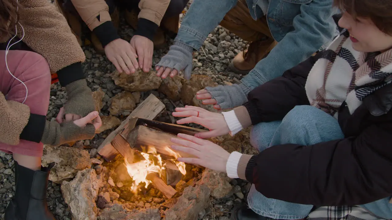 Camera Focuses The Hands Of A Group Of Teenagers Near The Bonfire