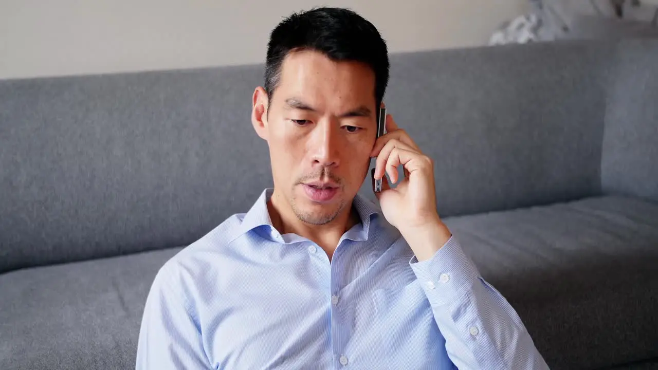 Man talking on mobile phone in living room