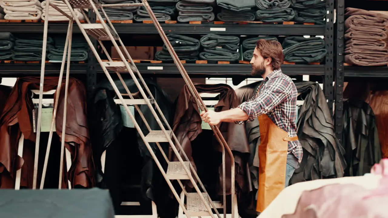 Fabric boutique and man in workshop with ladder