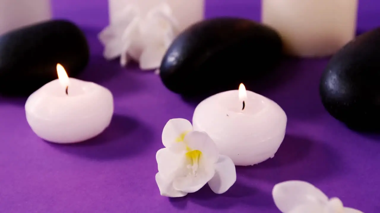 Pebbles flowers and candle on table