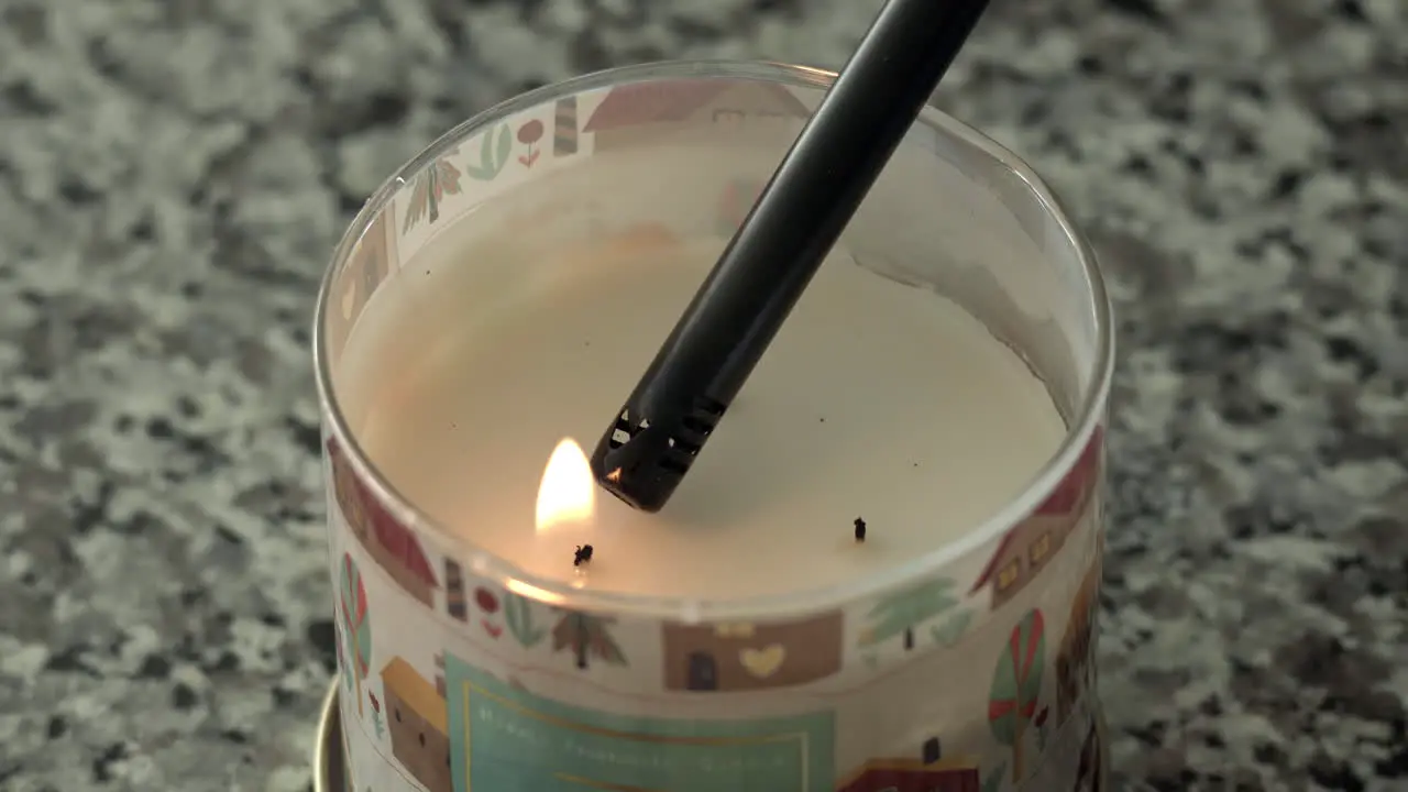 Close up as fall holiday candle on countertop is lit with a candle lighter 4K