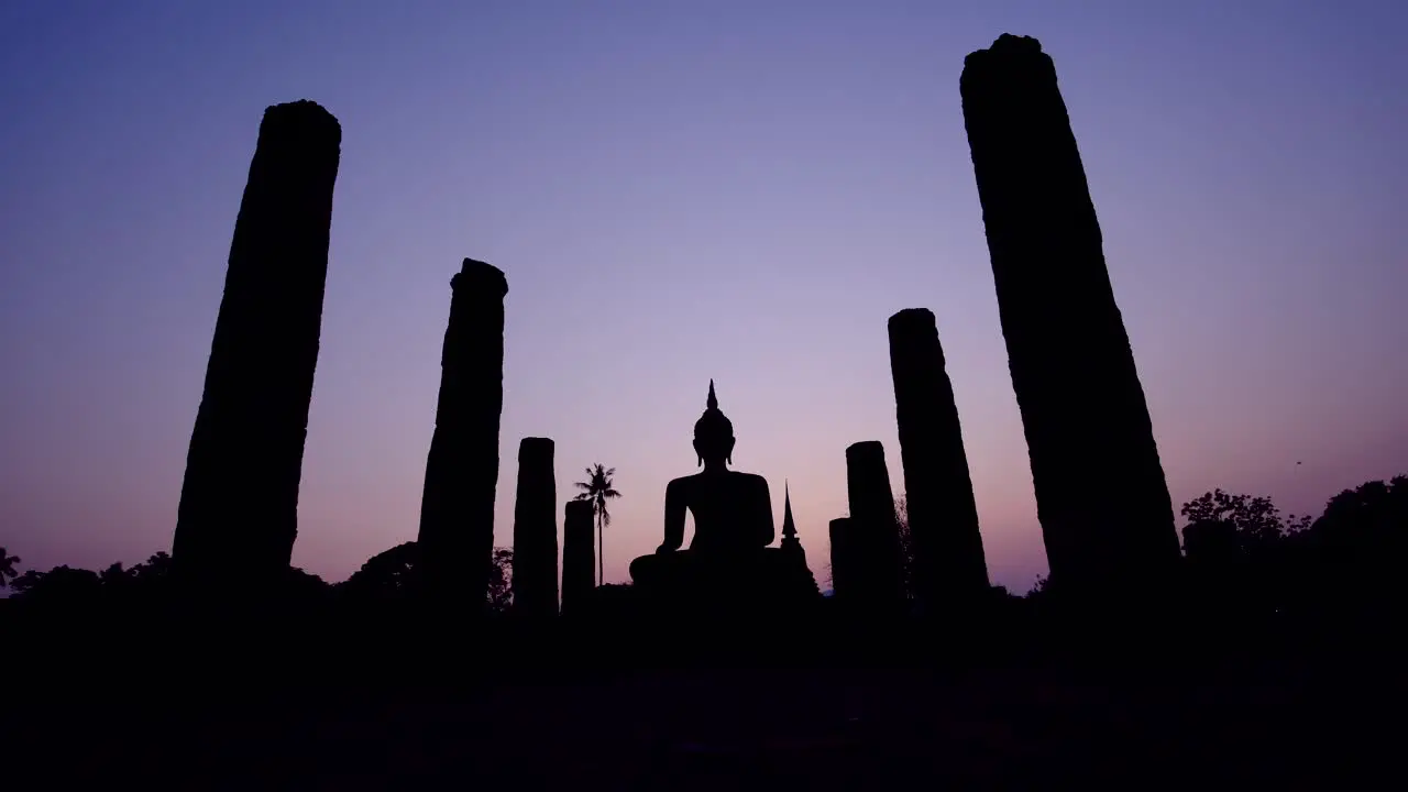 Dramatic silhouettes background a post and buddha during sunset