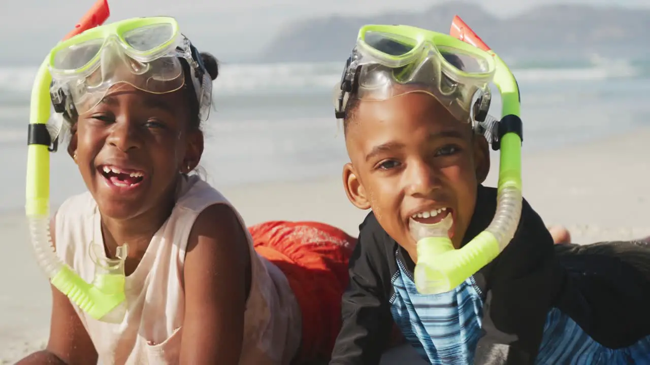 African american brother and sister wearing scuba diving mask with a snorkel at the beach