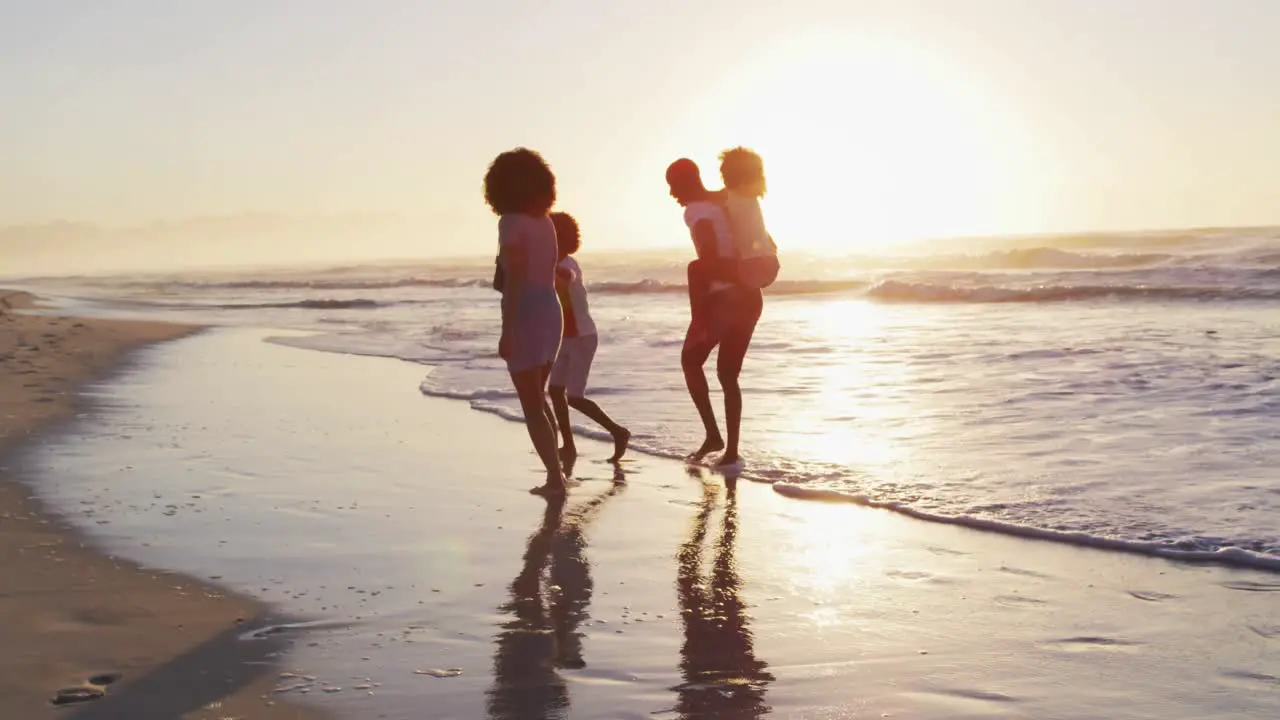 African american family having fun together during sunset on the beach