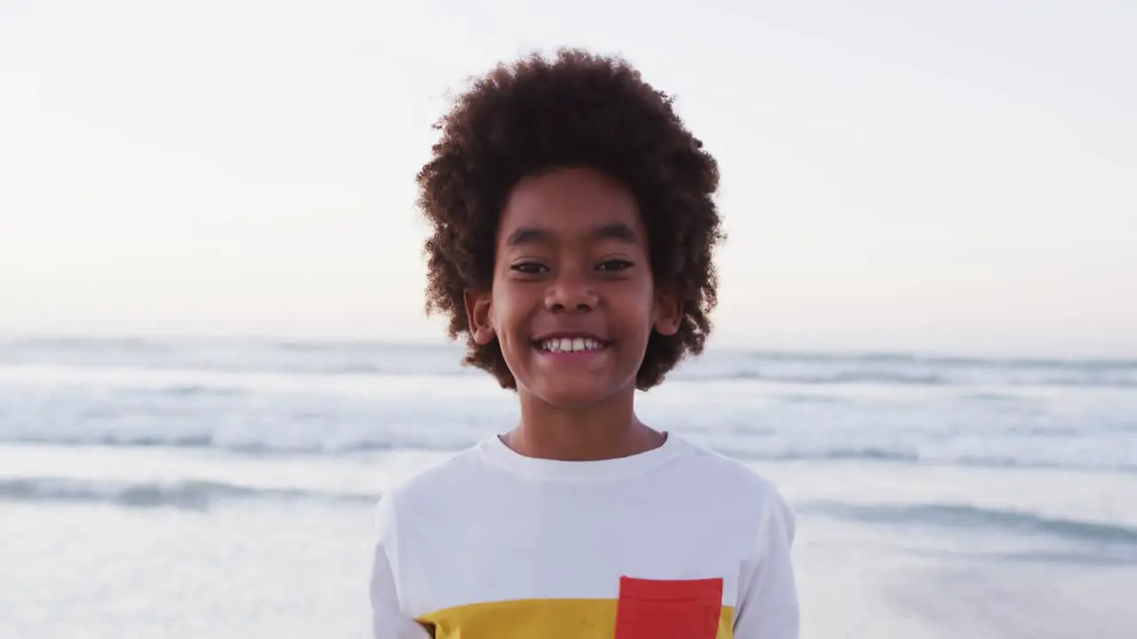 Portrait of african american boy smiling while standing at the beach