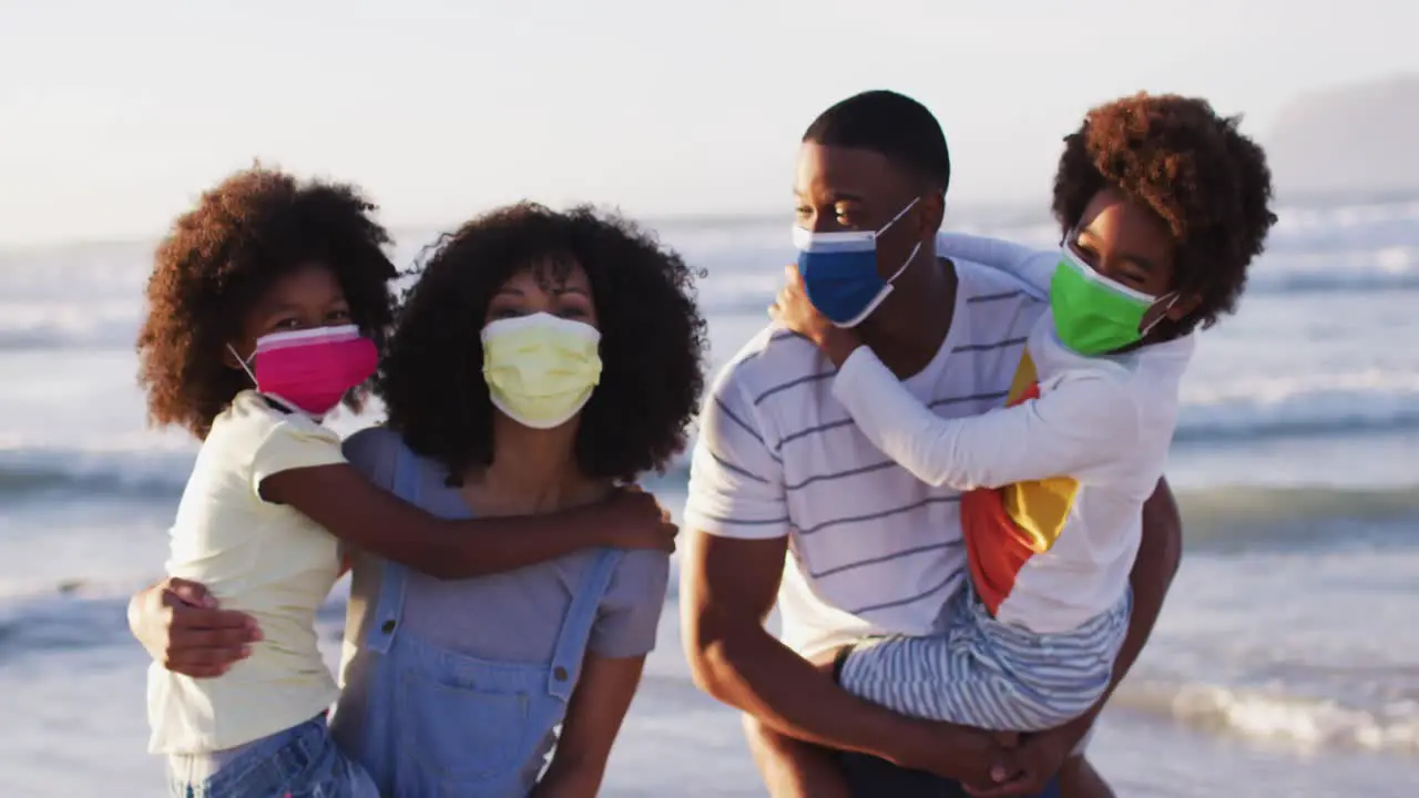 Portrait of african american family wearing face masks at the beach