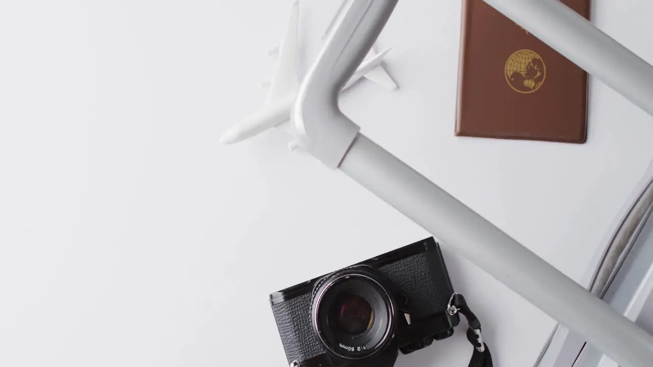 Close up of passport suitcase plane model and camera with copy space on yellow background