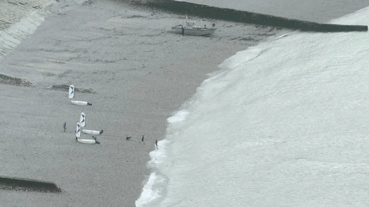 few kids with 3 sailboats after sailing course in the coast a speedboat back