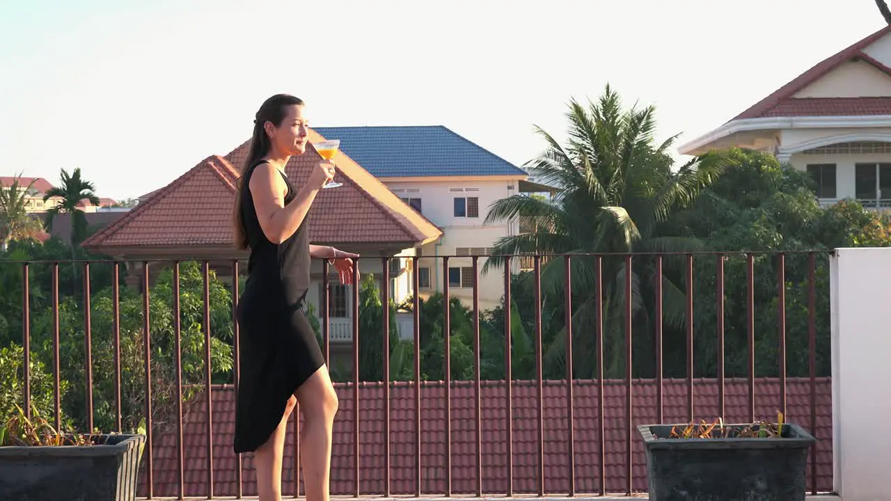 Long Shot of a Beautiful Young Lady Enjoying a Cocktail on a Tropical Hotel Rooftop