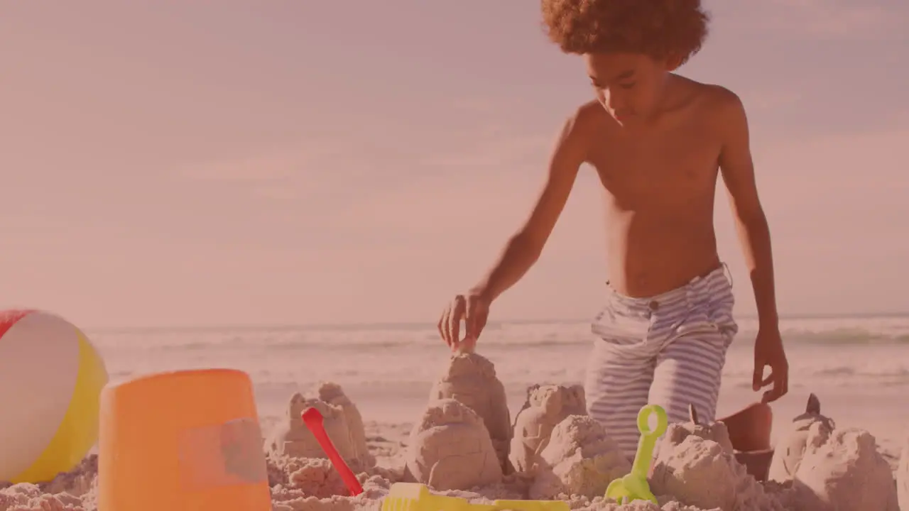 African american young boy building sand castles at the beach