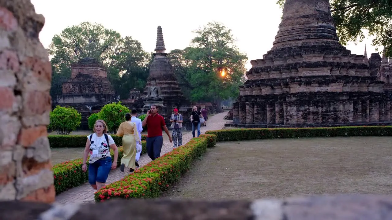 People walking out from a tourist attraction building Sukhothai- the oldest city in Thailand