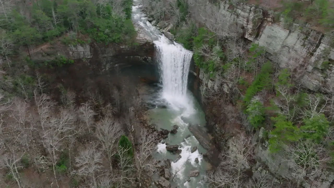 Wide aerial shot of waterfall with a pan down at the end