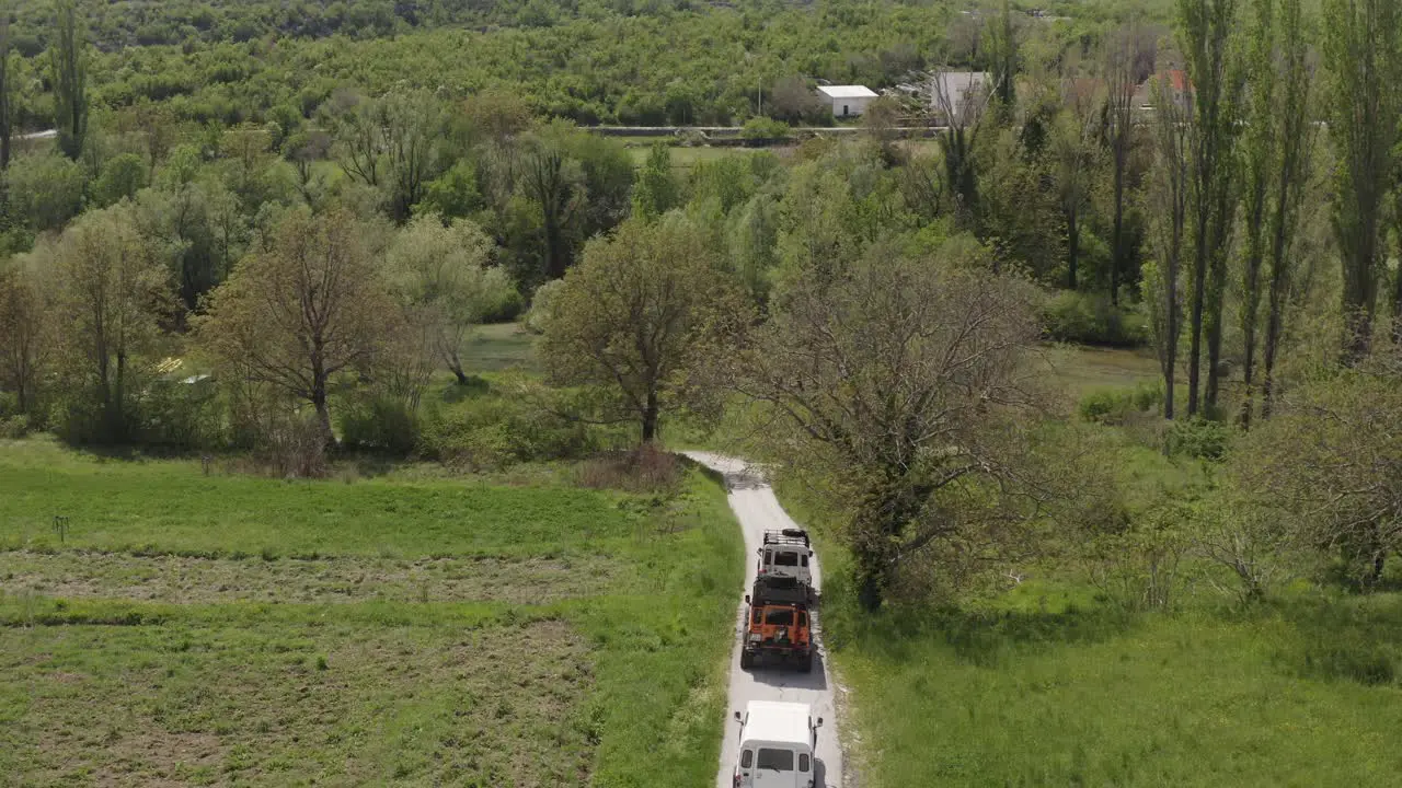 Land rovers drive along a beautiful road in nature