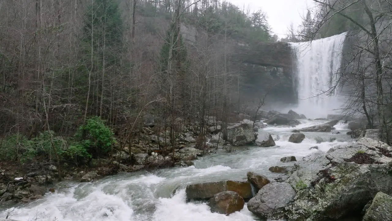 Slow dolly forward of creek and waterfall that are flooded