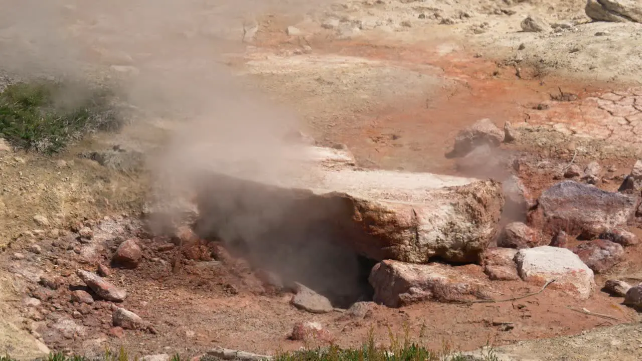 Closeup of steam rising from underneath rock in Yellowstone National Park