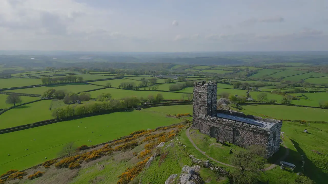 Aerial view of a remote medieval church overlooking green fields in the uk