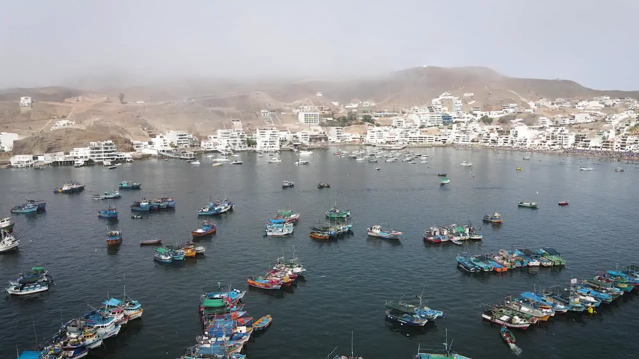 Drone shot of the coast of Pucusana with fishing boats and beach houses during summer