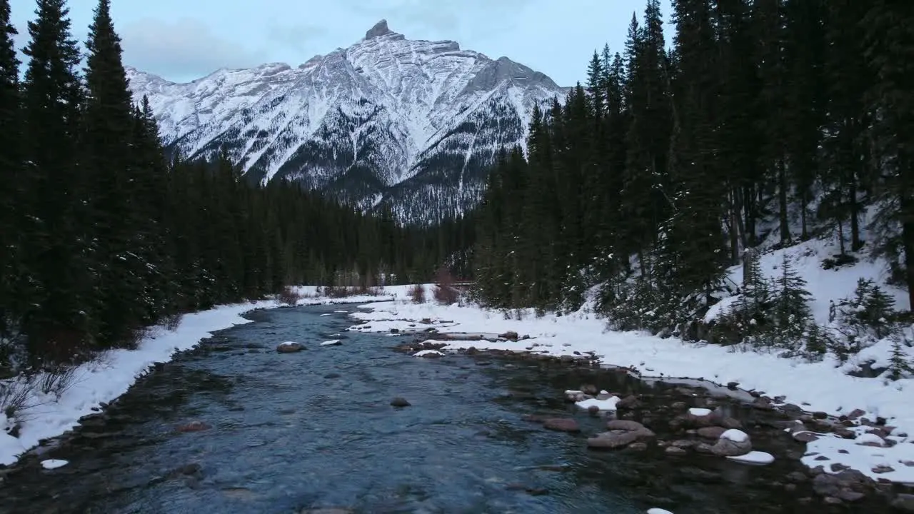 Creek in mountain forest bridge downstream reveal winter