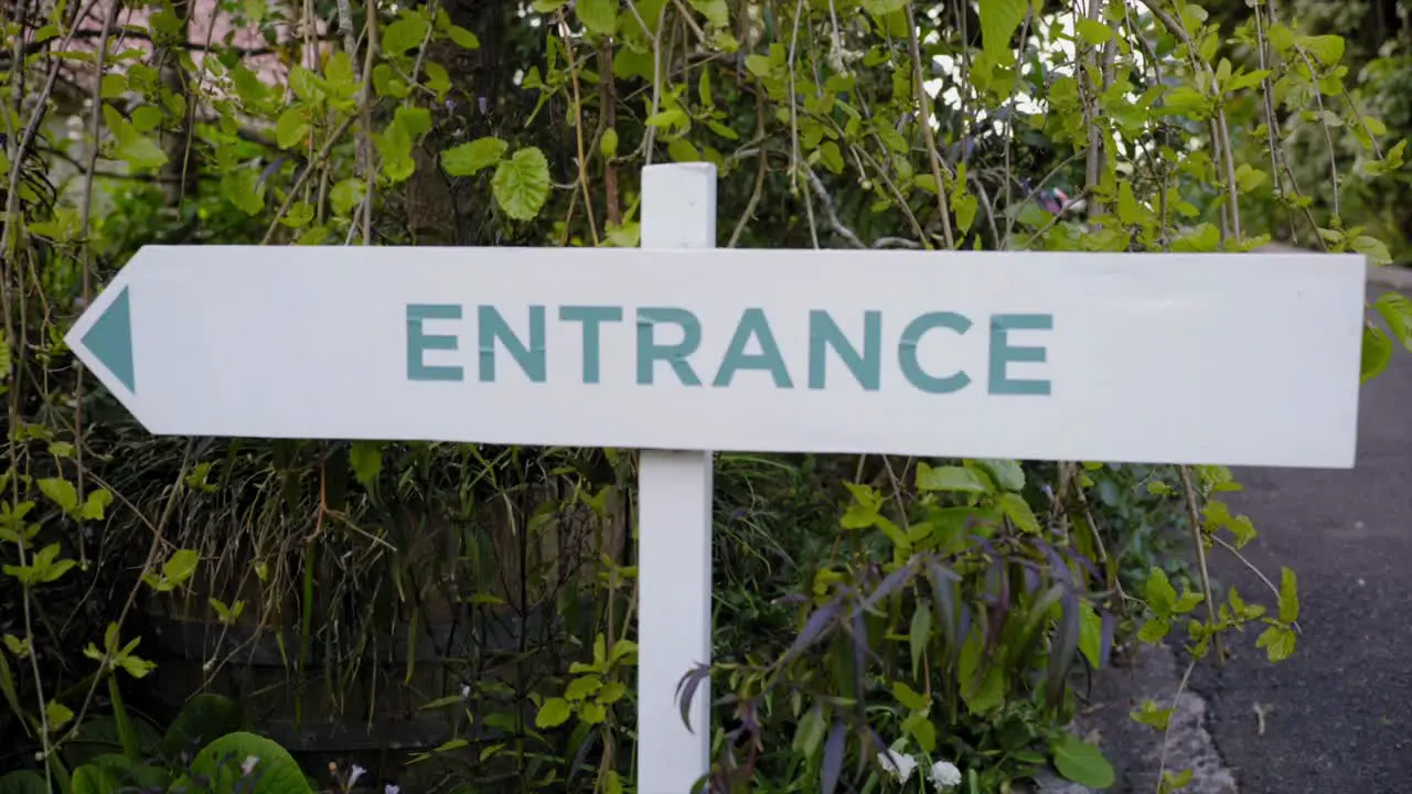 closeup of entrance road sign and green plants behind