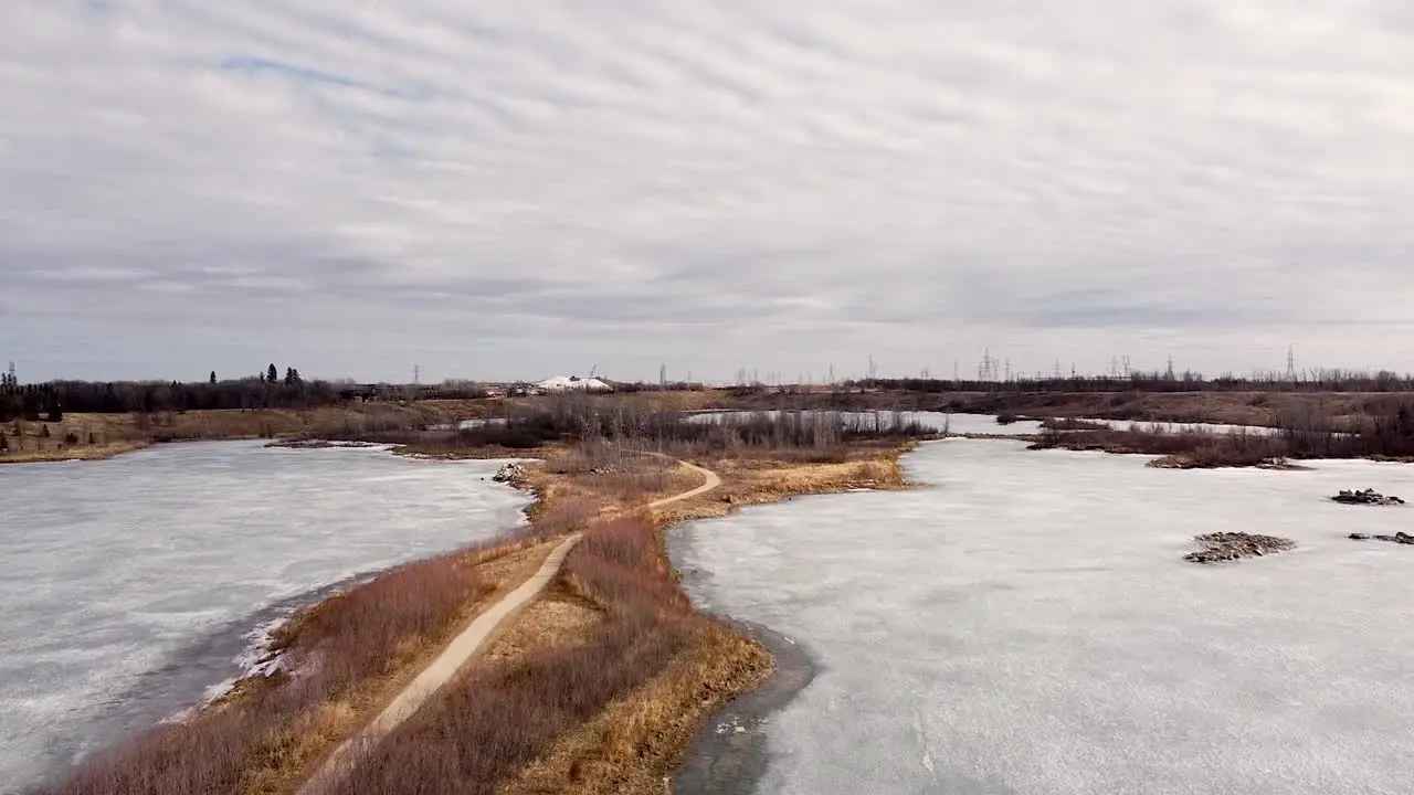 Drone Moving Up Park Path Frozen Pond