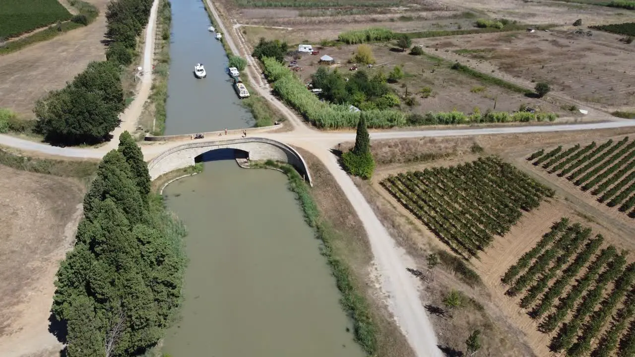 Boat going under a historic bridge on The Canal Du midi South Of France