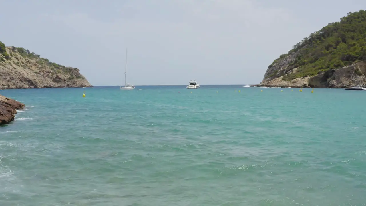 Small bay in Ibiza Island with boats and bridge in front of the mediterranean sea